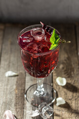 Berry alcoholic cocktail liqueur, vodka, ice and mint Refreshing drink on wooden table