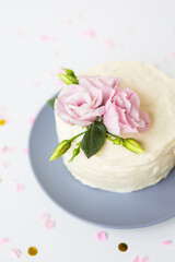 Very beautiful small white cake decorated with fresh eustoma flowers. Holiday concept.