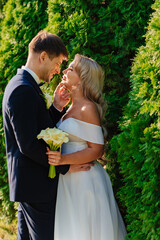 happy newlyweds. groom and bride in traditional wedding clothes kiss in park