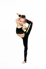 Gymnastic tricks. A flexible little girl gymnast in a sports black suit keeps her balance while standing on one leg and does acrobatic exercises