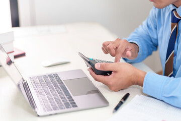 Fototapeta premium Business accounting concept, Business man using calculator with computer laptop, budget and loan paper in office.