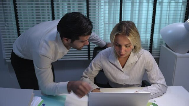 Caucasian businessman sexually harassing female colleague.