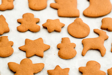 Fresh baked homemade Chritstmas gingerbread cookie on a baking paper. Selective focus
