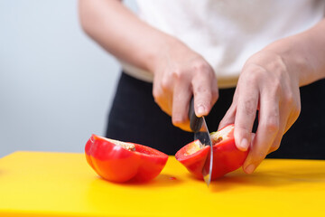 Young woman cooking romantic dinner at home cutting vegetables close-up ,Closeup of human hands cooking vegetables salad in kitchen on the glass table with reflection