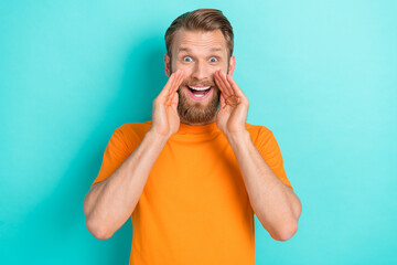 Photo of cool brown hairdo guy tell secret wear orange t-shirt isolated on turquoise color...