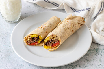 Turkish meat doner wrap on gray background. Traditional flavors. Doner kebab made from beef and lamb. close up