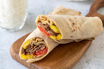 Turkish meat doner wrap on gray background. Traditional flavors. Doner kebab made from beef and...