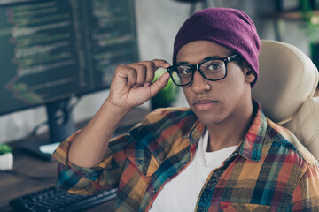 Photo of confident cool guy dressed eyewear hat working front end engineer modern device indoors...