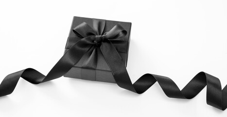 Black Friday Sale and Christmas present. Gift box with black ribbon isolated on white.