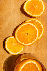 Oranges sliced on a wooden surface in the light of the sun.