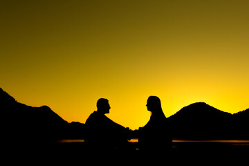 Fototapeta na wymiar silhouette of a couple on the lagoon