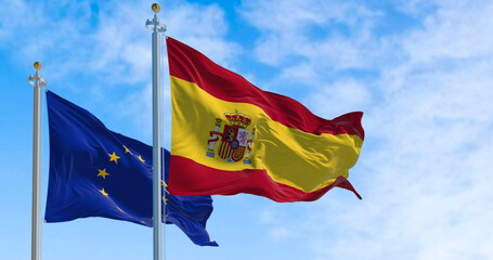 the flags of Spain and the European Union waving in the wind on a sunny day.