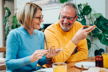 Senior couple eating breakfast at home and spending morning together