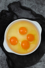 few yellow egg yolks in a white bowl