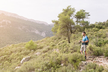 Naklejka na ściany i meble Adult man practicing trekking in the mountains.