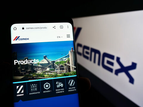 Stuttgart, Germany - 10-23-2022: Person holding cellphone with webpage of Mexican materials company CEMEX S.A.B. de C.V. on screen with logo. Focus on center of phone display.