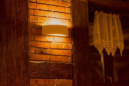 Fototapeta Ścienna lamp (kinkiet) na ścianie domu z cegły i drewnianych belek . Stylizacja historyczna nowego domu .