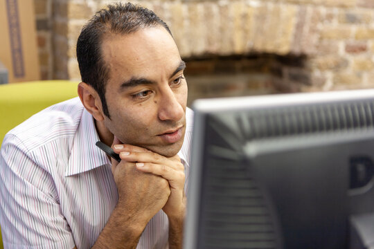 The Media Agency: At the Monitor. A mature office worker candidly concentrating on his computer screen. From a series of related images.
