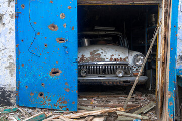 War in Ukraine. 2022 Russian invasion of Ukraine. A destroyed civilian car is in the garage. On the...