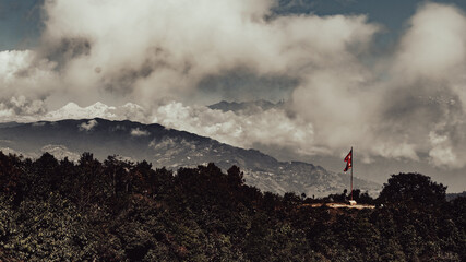 Nepal flag with the himalayas being covered by clouds