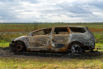 War in Ukraine. 2022 Russian invasion of Ukraine. Countryside. A destroyed burnt-out civilian car...