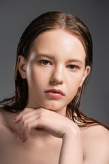 Fototapeta premium Young woman with wet skin and naked shoulders isolated on grey