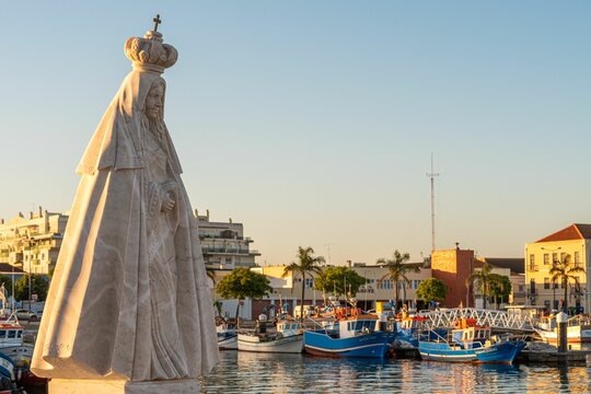 Beautiful sunset at the port of Setubal in Portugal and a statue