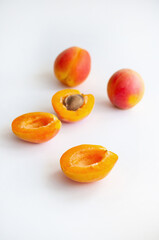 Sweet ripe cut and whole apricots with a seed on white background with copyspace.