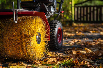 Kehrmaschine mit Bürste zum säubern des Bodens im Herbst
