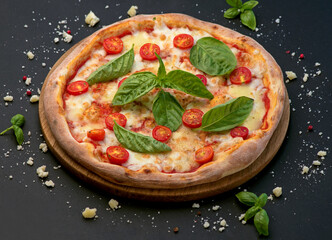 Traditional Italian pizza, vegetables, ingredients on a dark background. Pizza is cooked in the oven.