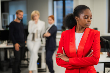 Young african woman is upset because of the ridicule of colleagues. Racial discrimination in the...