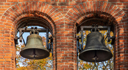 Obraz premium General view and architectural details of the brick belfry built in 1875 and the Catholic Church of the Immaculate Conception of the Blessed Virgin Mary in Ceranów in Mazovia, Poland.