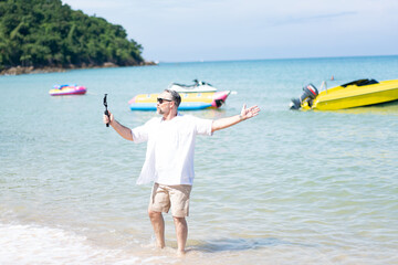  Man taking selfie of himself after workout. Good looking taking a self-portrait picture with his smartphone camera on a beach during summer vacation travel.