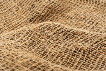 Burlap texture. Burlap fabric background with waves, folds and bruises