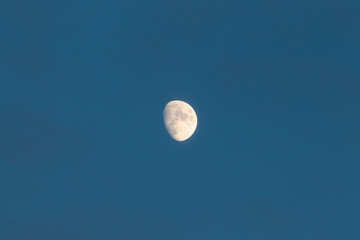 Centered view of waxing gibbous phase moon during blue hour and clear sky