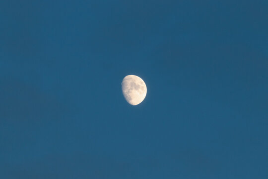 Centered view of waxing gibbous phase moon during blue hour and clear sky