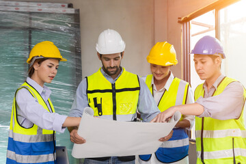 group of construction worker team working together discussion looking floor plan at construction site planning build process