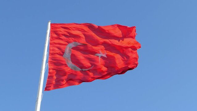 Flag Of Turkey Fluttering In The Wind 4K. T&uuml;rkiye flag waving in slow motion in the wind over blue sky 4k