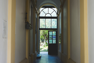 Elegant corridor of a mansion or public institution with exit to the garden through a door at the end of the hall