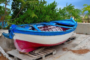 characteristic colorful wooden fishing boat in front of the civic museum of ricadi capo vaticano...
