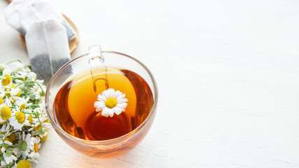 cup of herbal chamomile tea with fresh daisy flowers on wooden background. doctor treatment and prevention of immune concept, medicine - folk, alternative, complementary, traditional medicine