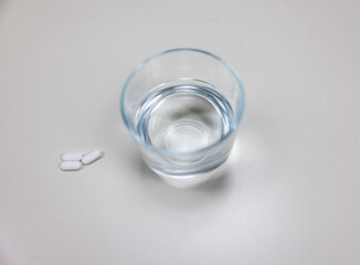 A photo showing a glass with water and pills. Painkillers, Antidepressants. Addicted. Social problem. Healthcare. 