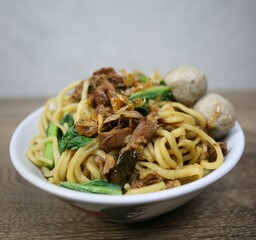 Indonesian street food. Chicken noodles in a bowl. Top view.