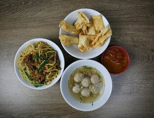 Indonesian street food. Chicken noodles in a bowl. Top view.