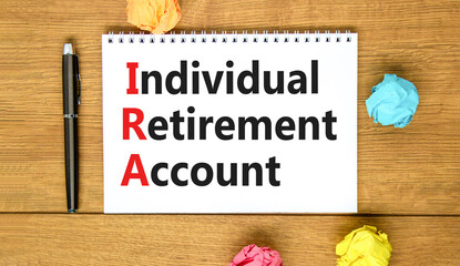 IRA individual retirement account symbol. Concept words IRA individual retirement account on white note on a beautiful wooden background. Business IRA individual retirement account concept. Copy space
