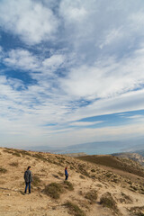 Fototapeta premium Dagestan, Russia - October 2020: Tourists walking on the mountain in the background of cloudy sky. The Chirkeyskoye reservoir is the largest artificial reservoir in the Caucasus. on the Sulak River.