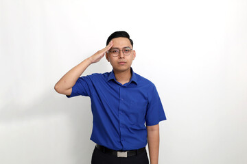 Fototapeta premium Young asian man standing with salute hand gesture and looking at the camera. Isolated on white