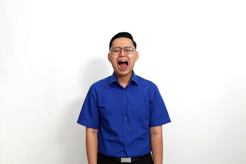 Fototapeta premium Frustrated young asian man standing while shouting or screaming. Isolated on white background