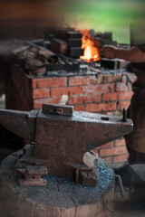 Anvil and hammer in a forge with an open fire. Blacksmithing and metalworking.