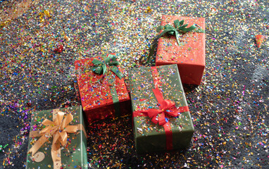 Gift present boxes with colorful confetti party popper pattern texture background on carpet on the floor. Celebration event